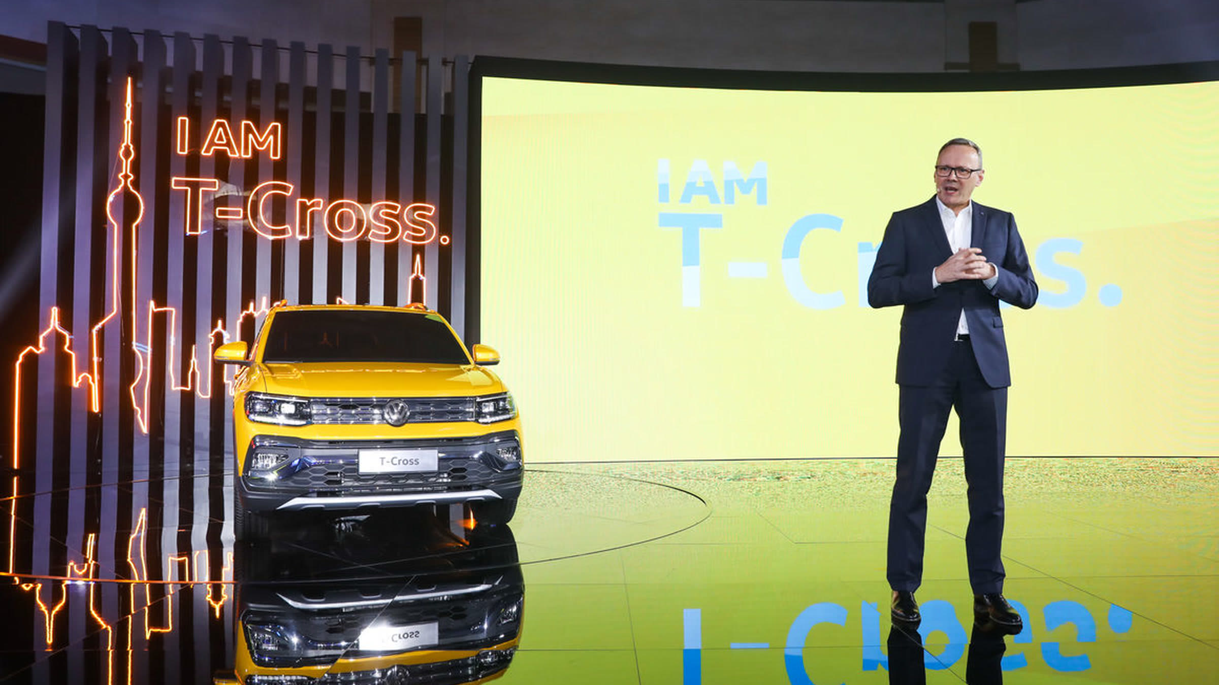 T-Cross launch, presenter on stage with yellow car